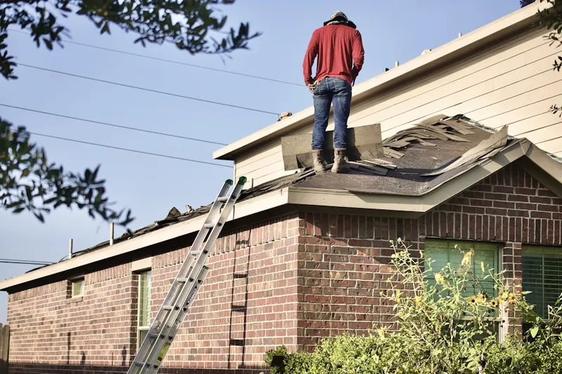 Professional roofer working on a residential roof in Colvin Farms
